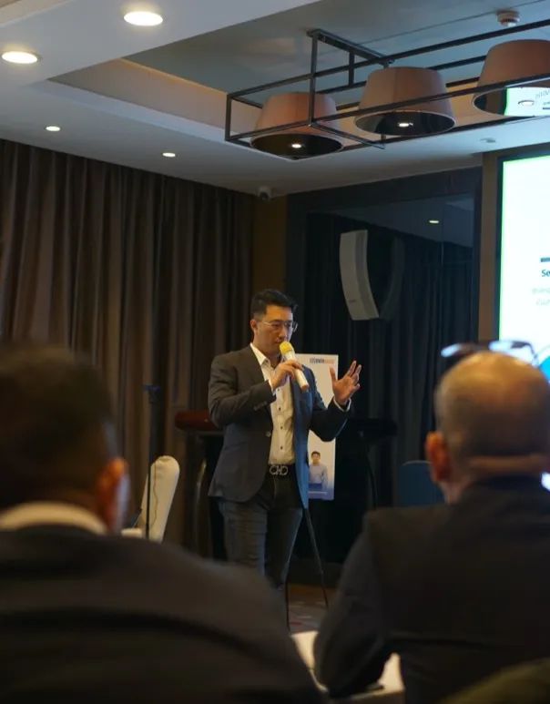 BGF team member speaking with a microphone at an event